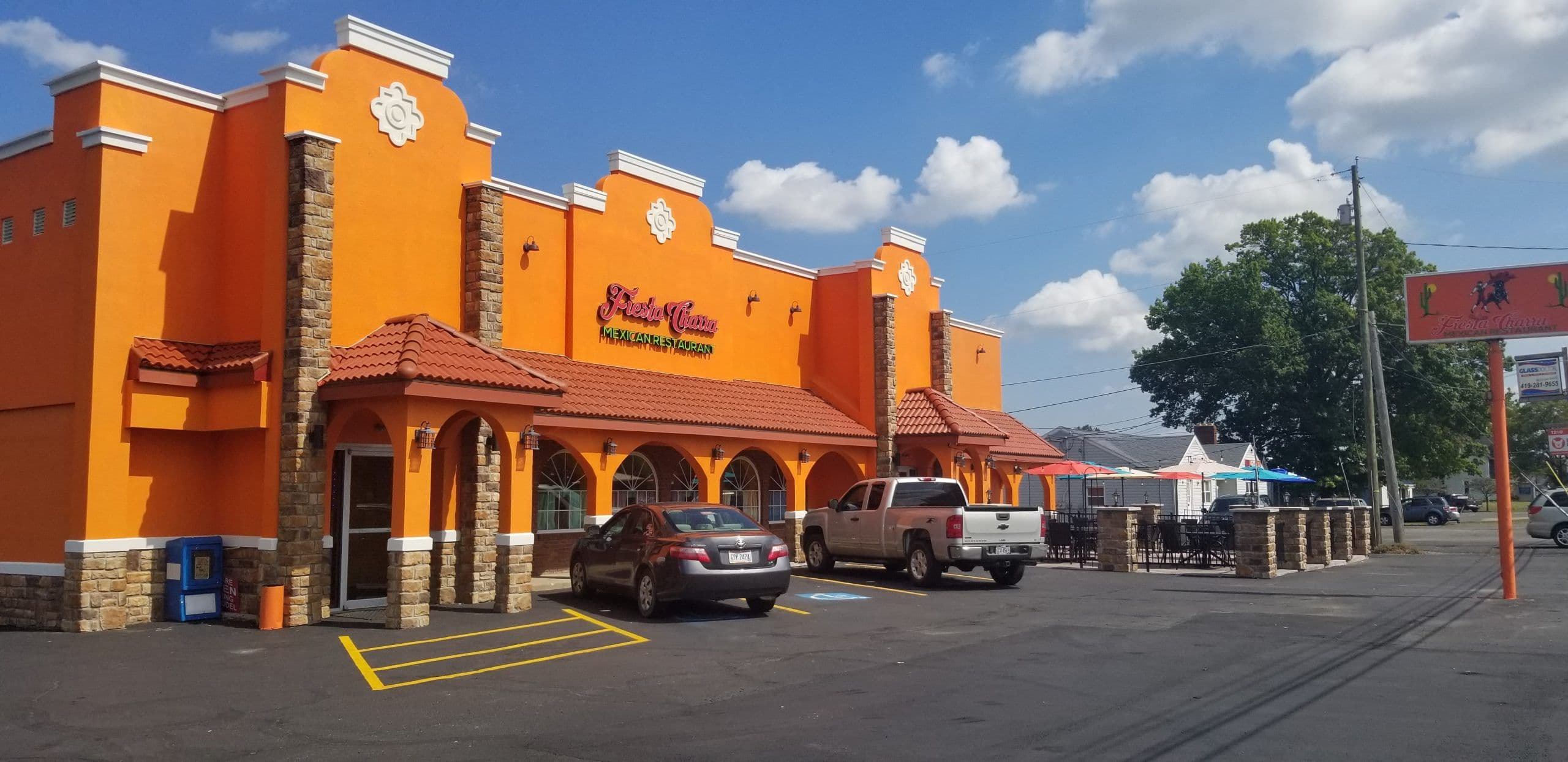 Fiesta Charra Mexican Restaurant after its addition and remodel, orange stucco with stone columns, clay-tile canopies and a restriped parking lot.